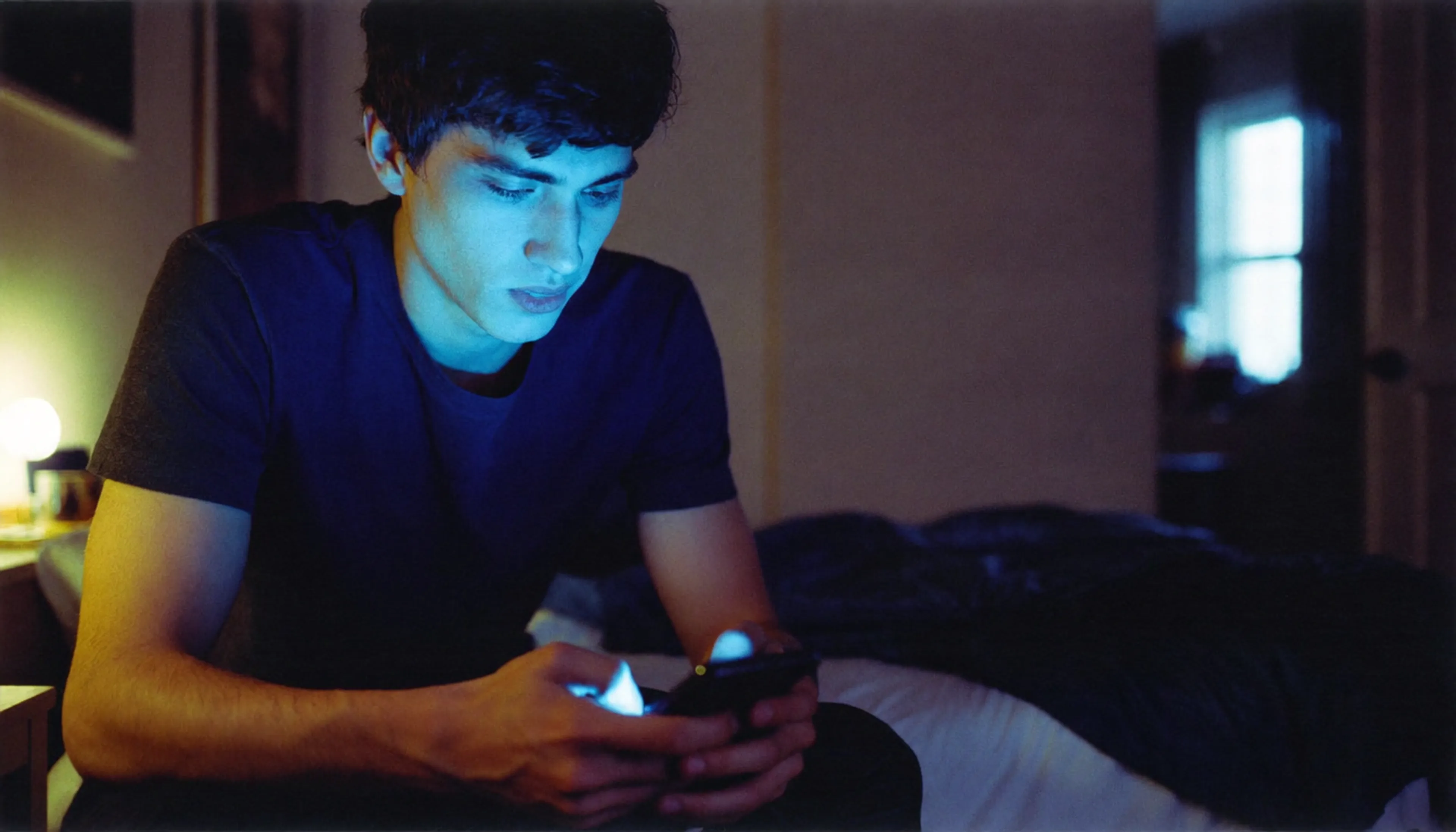 a young men looking for info on a mobile phone. Late night. erectile dysfunction triggers anxiety and can't make him sleep