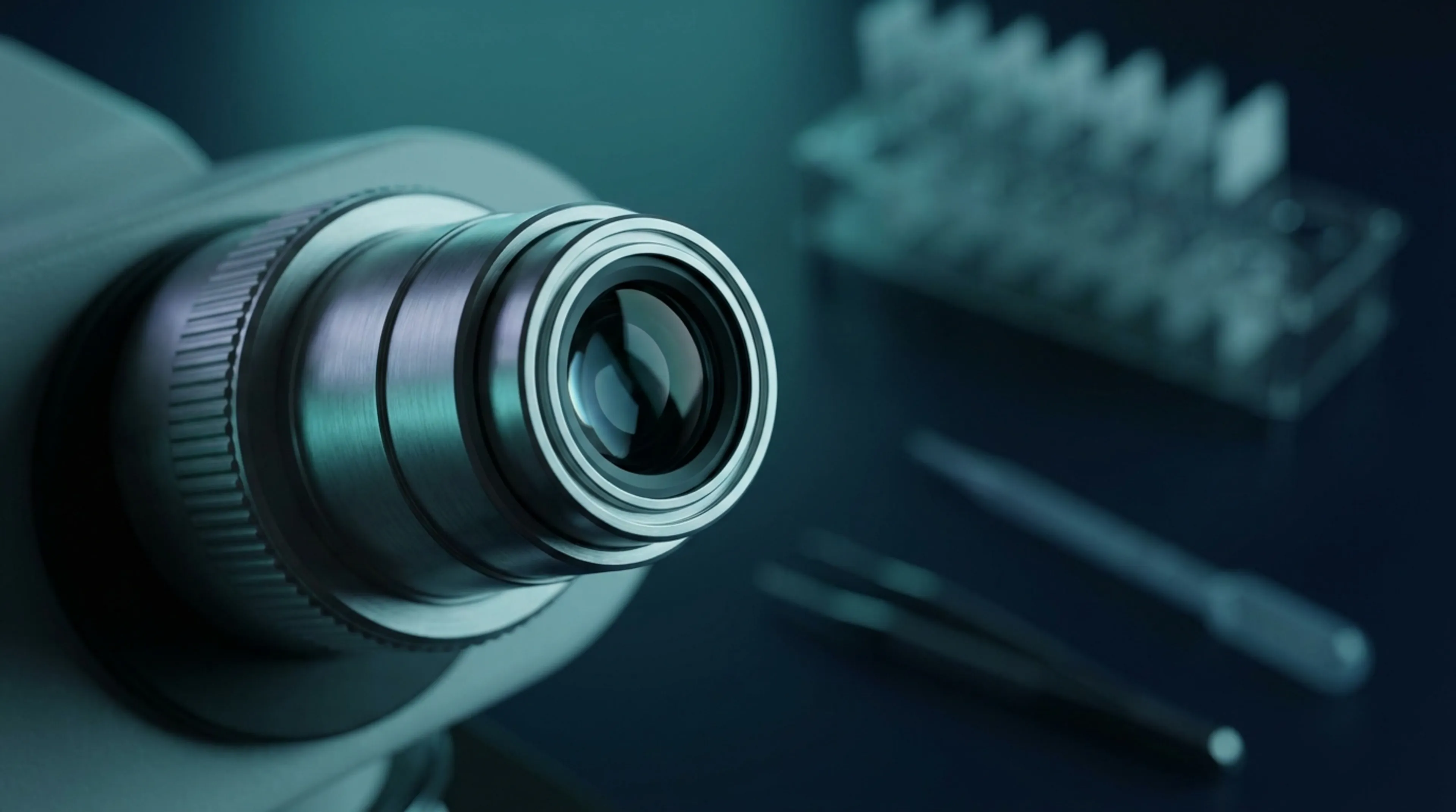 Close-up of a medical laboratory microscope with teal and navy blue lighting — semen analysis at GGOMed
