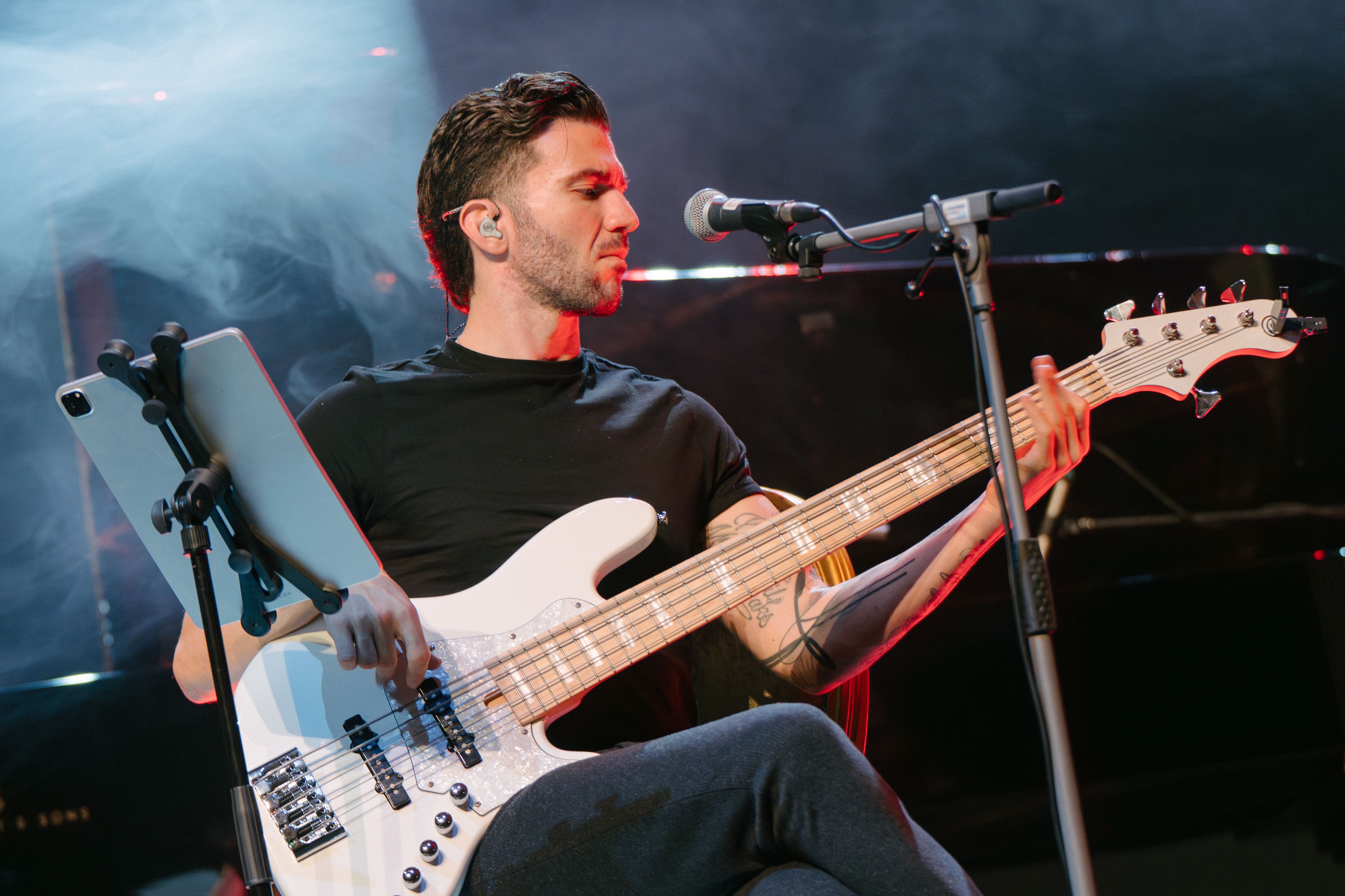 bassist sitting on stool