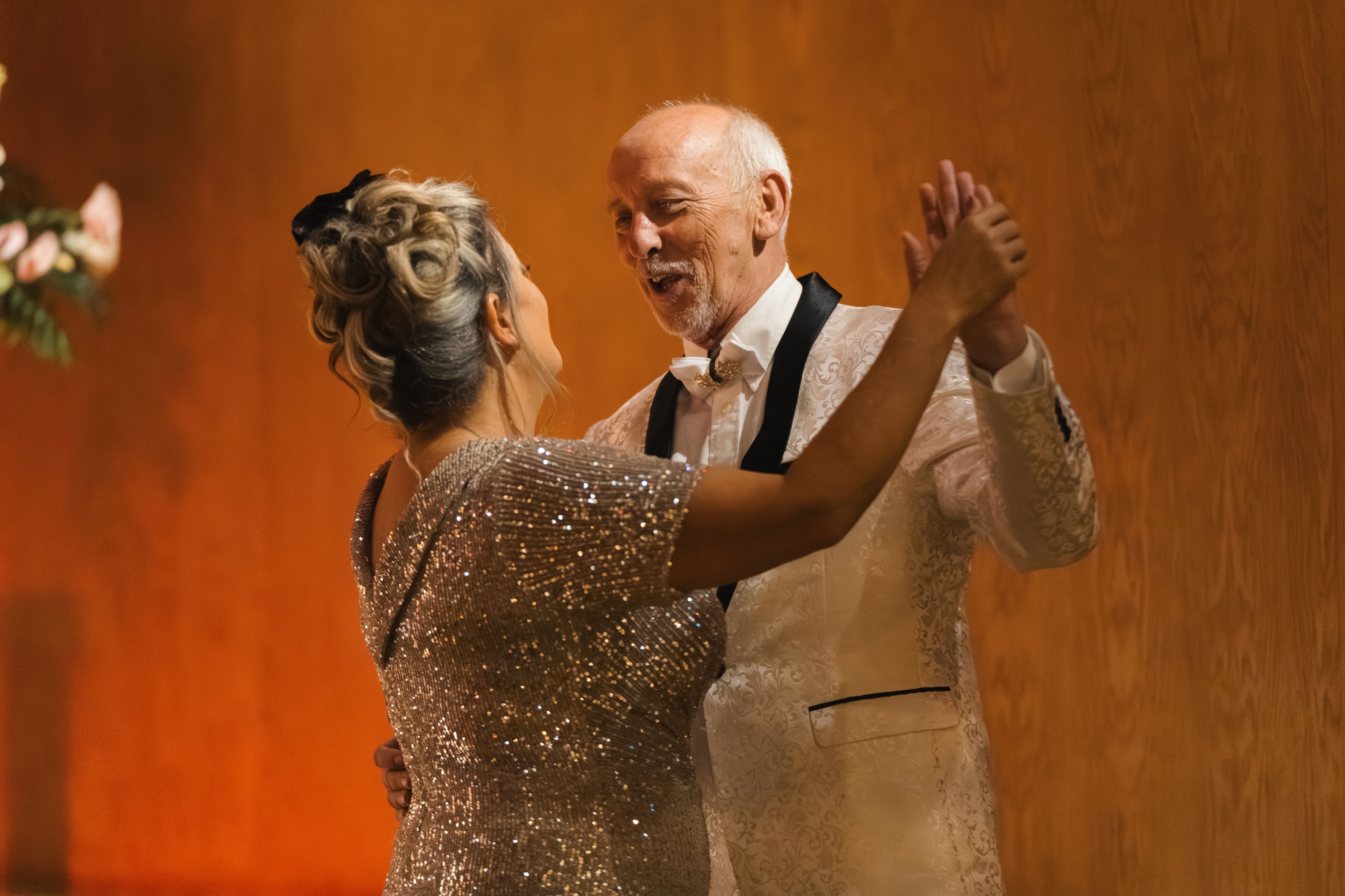 a man and woman in glittering formal clothing dancing