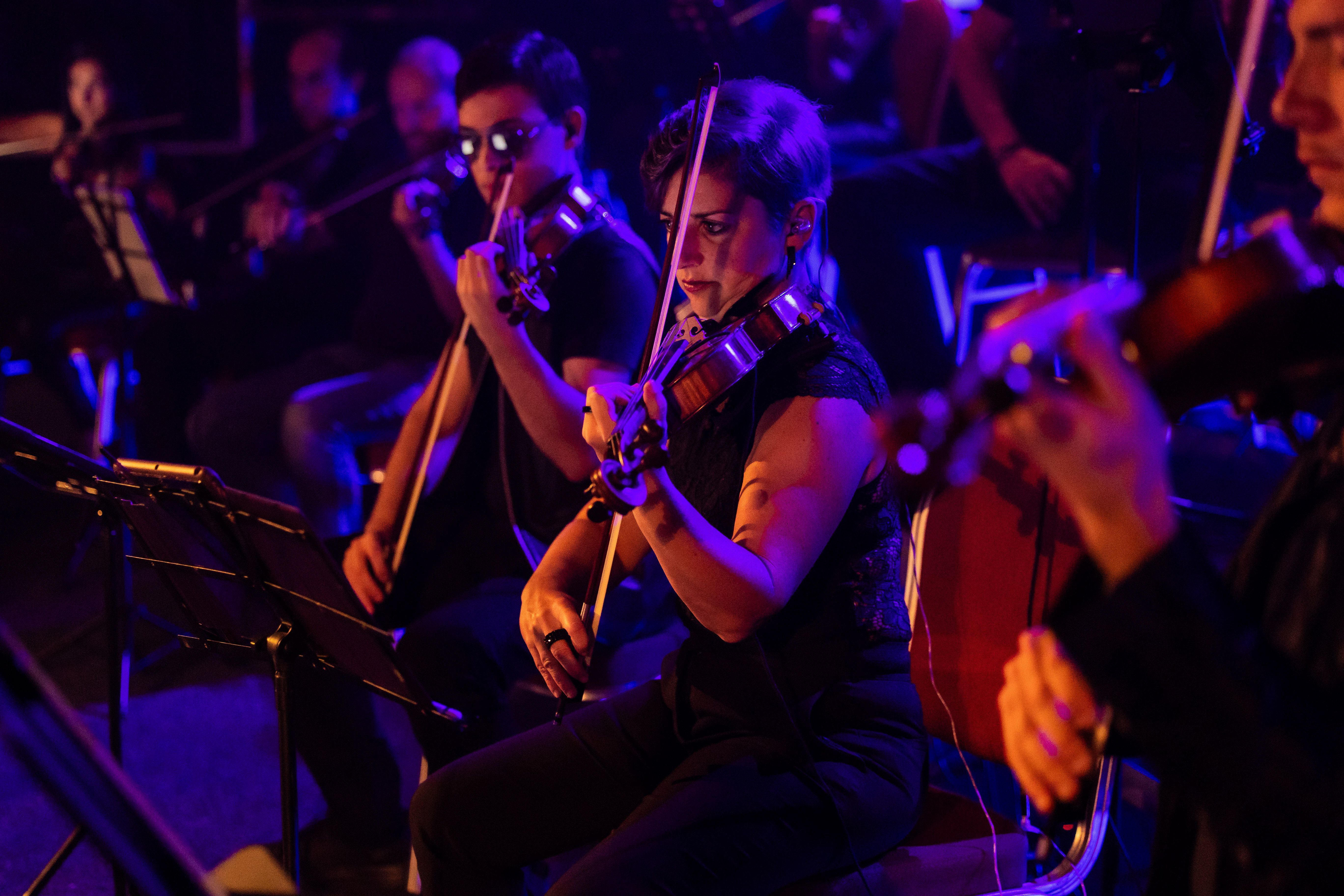 Violinist in casual outfits, one wearing sunglasses