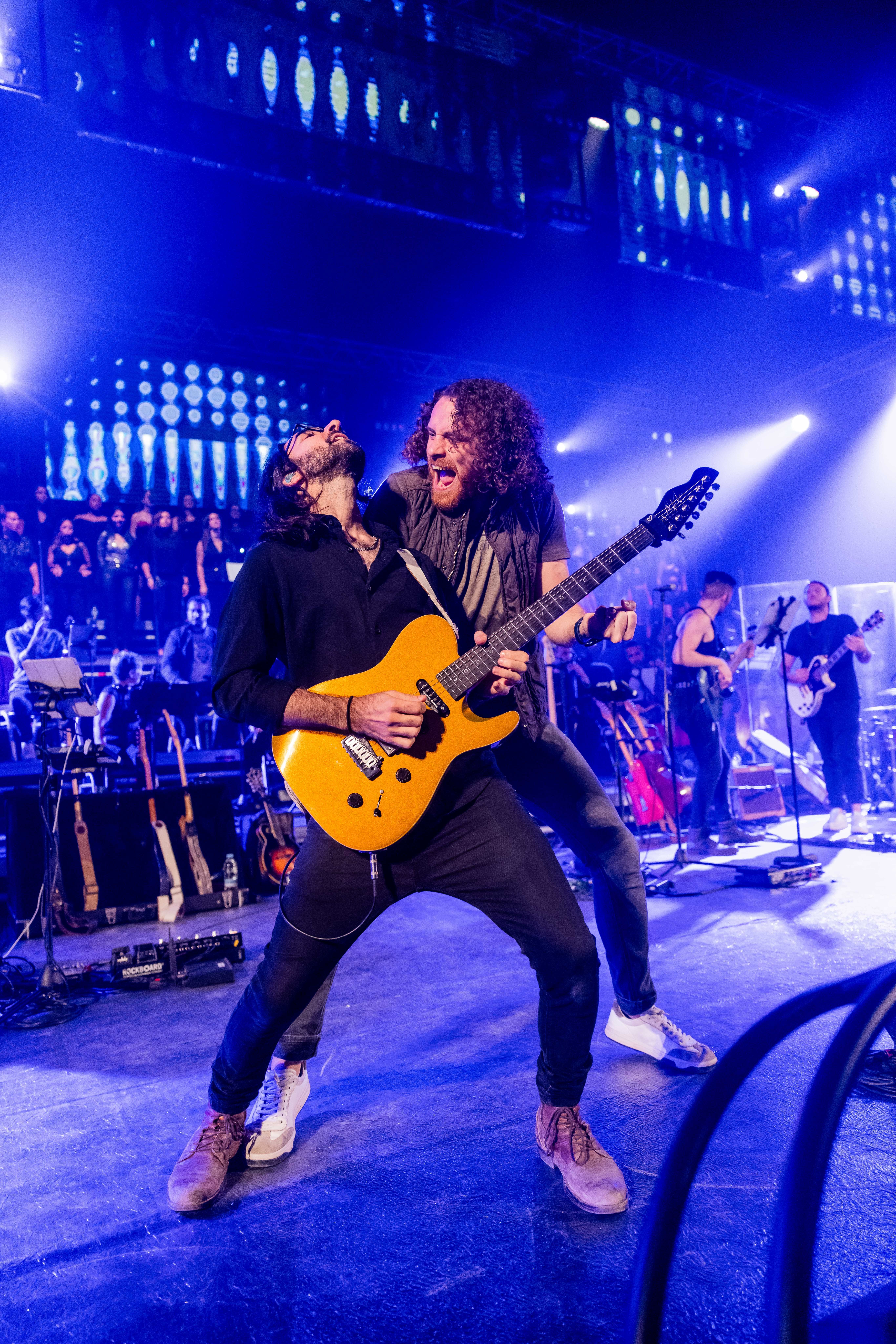 Guitarist and Rock singer on a blue lit stage