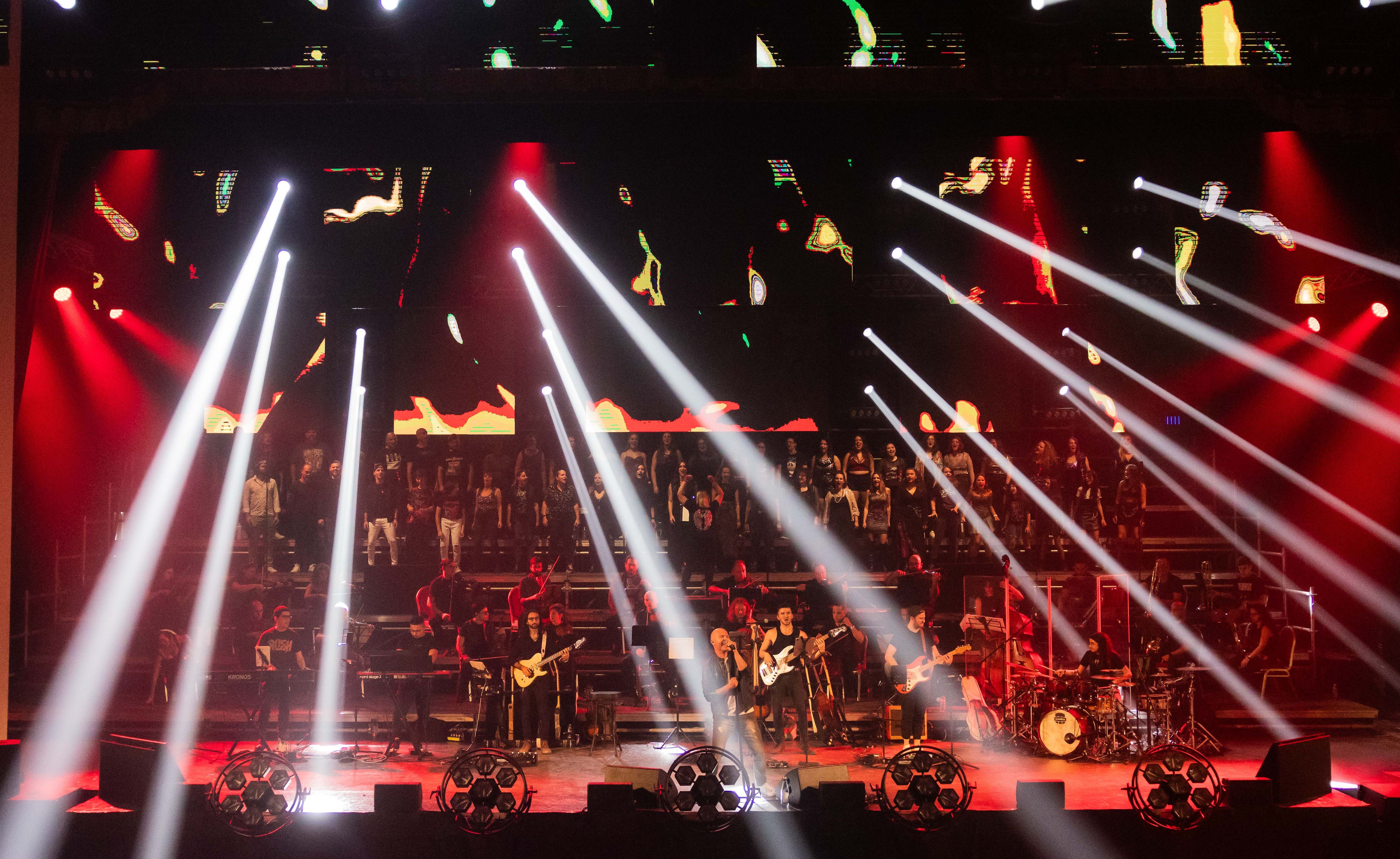 many spotlights in all directions and a colourful stage with musicians and choir lit in red