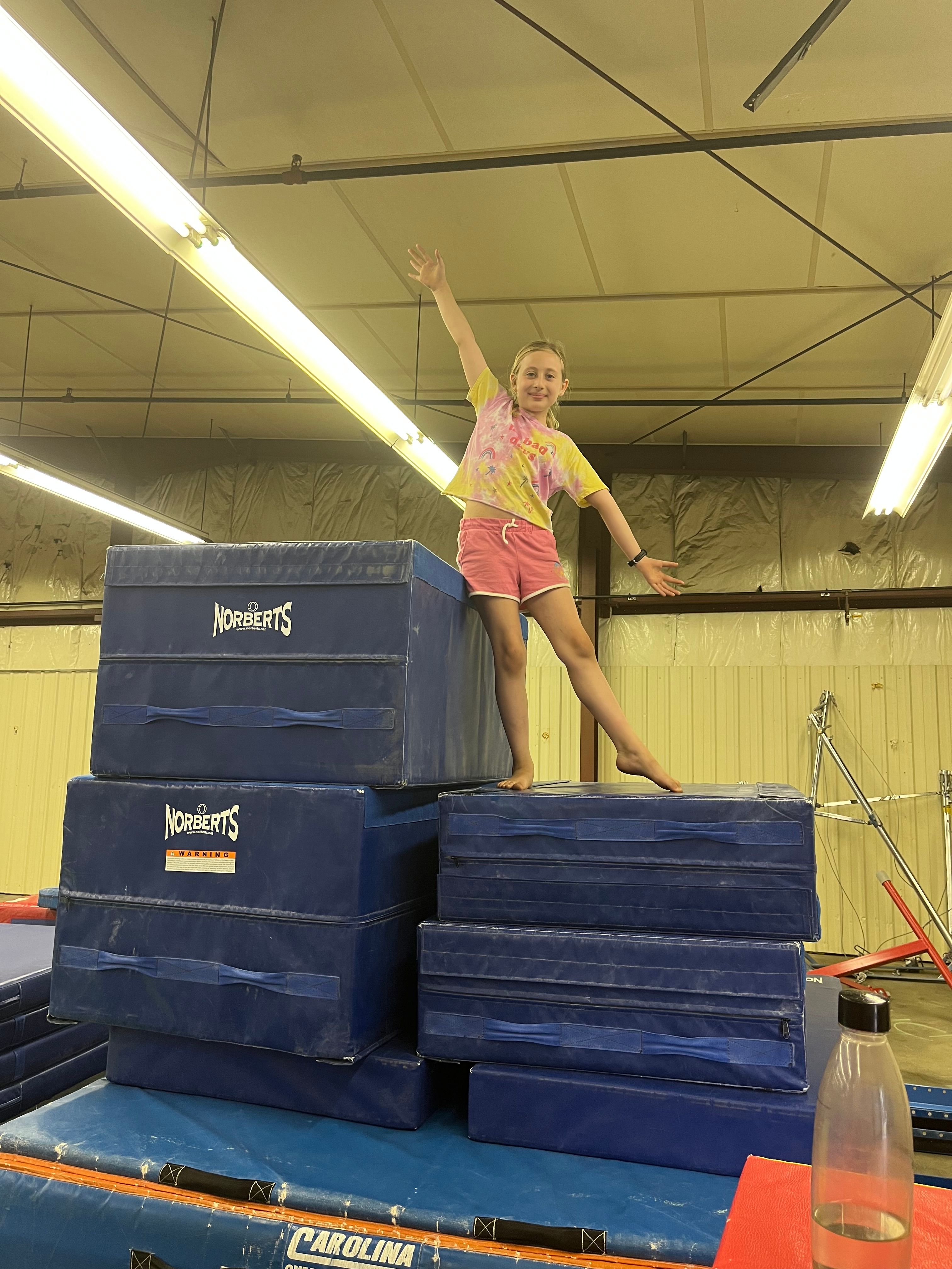 Gymnast standing on top of mats