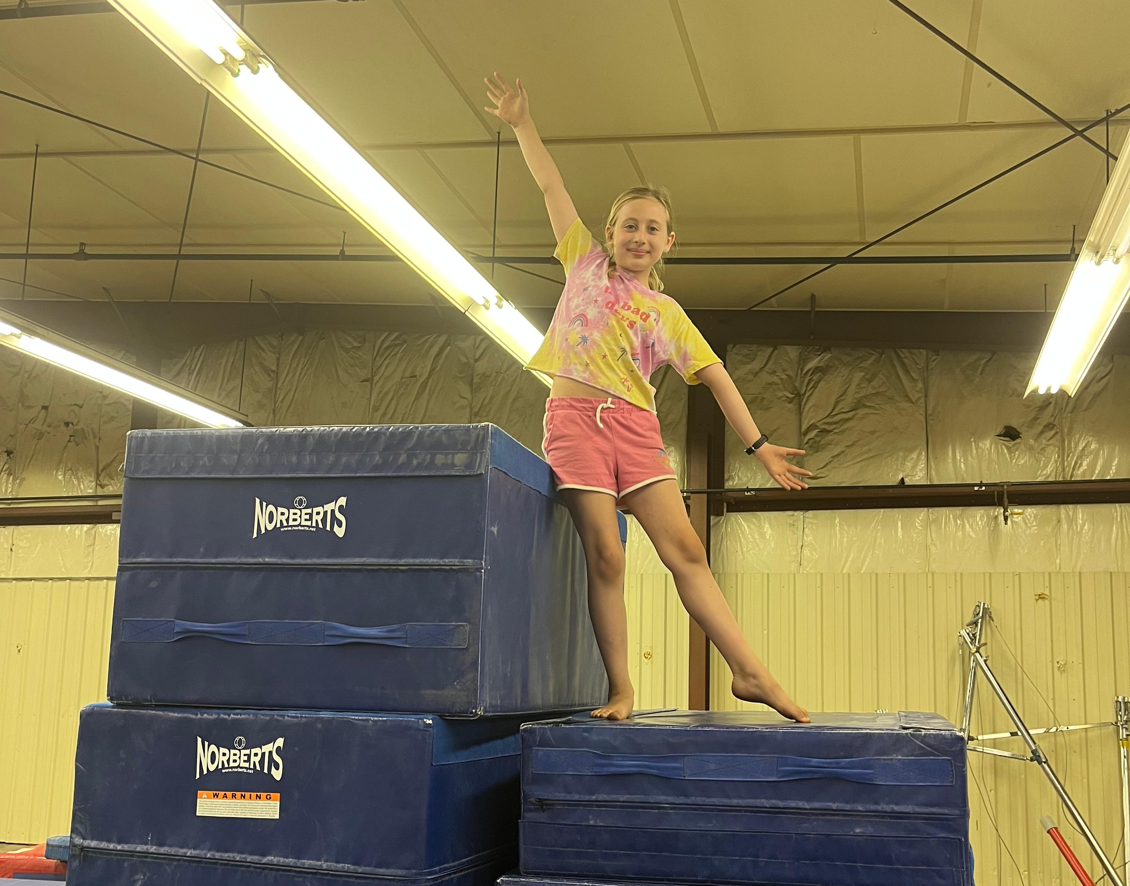 Gymnast standing on top of mats