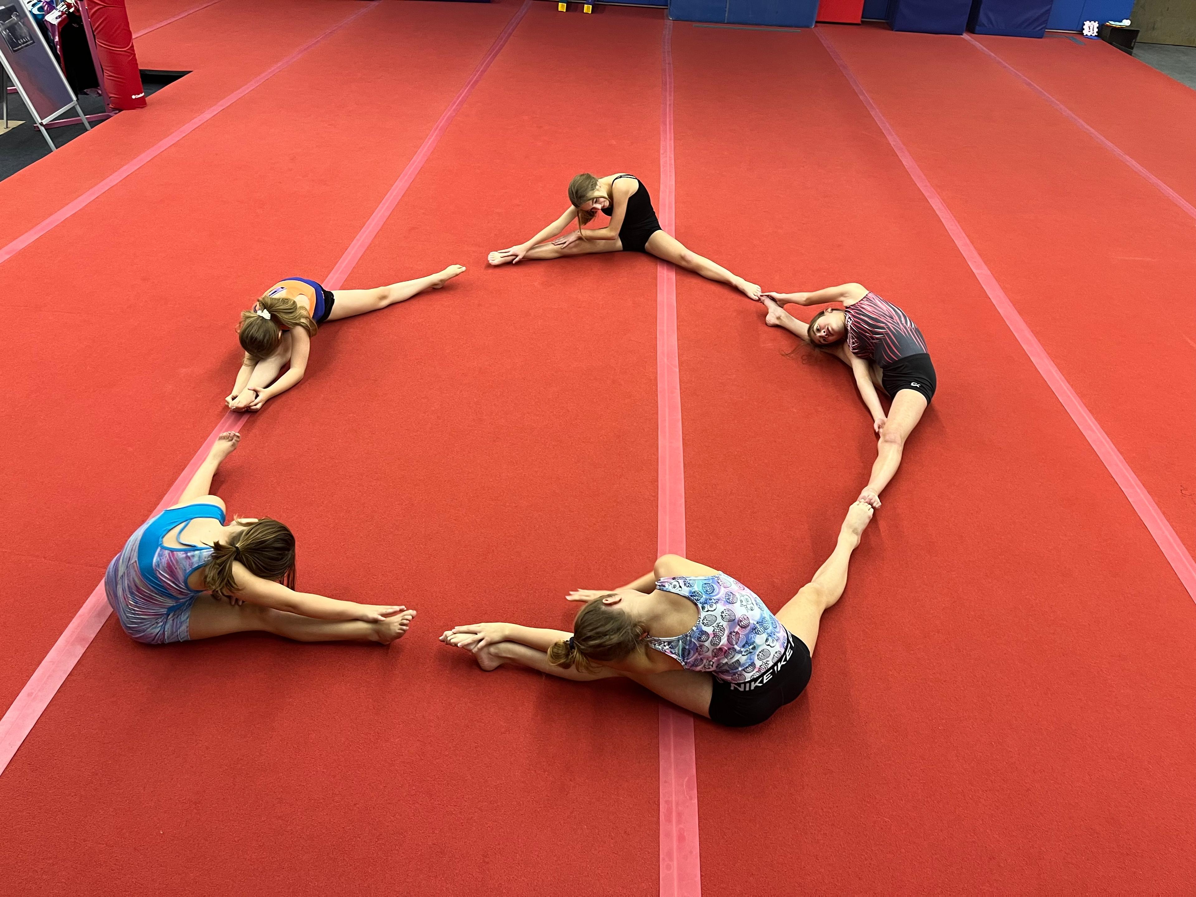 Gymnasts stretching on mat