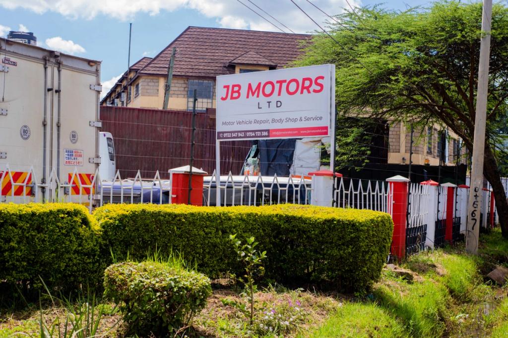 An image of JB Motors showing the premises from a side view. The JB Motors limited white board is seen.