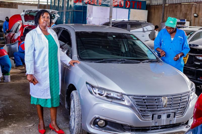 An image of Mary Wairimu (Manager) inspecting a vehicle
