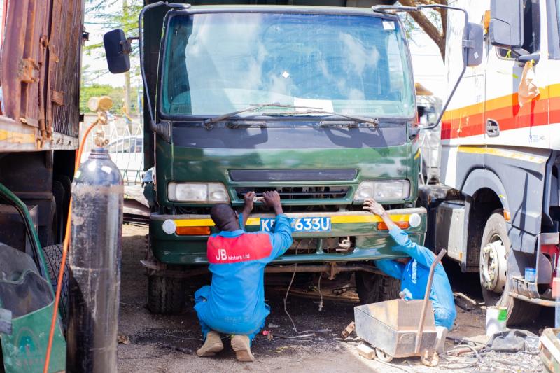 An image of JB motors mechanics working on a green lorry