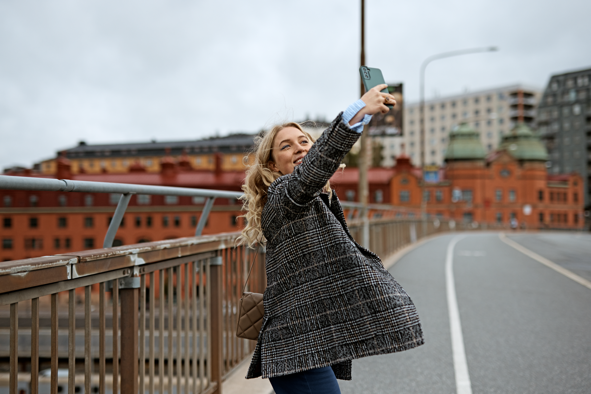 Glad kvinne tar en selfie i byen.