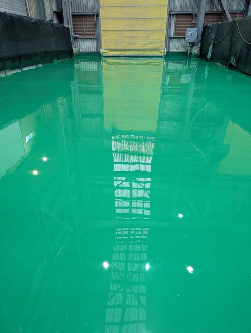 Piso industrial con revestimiento epóxico verde recién aplicado