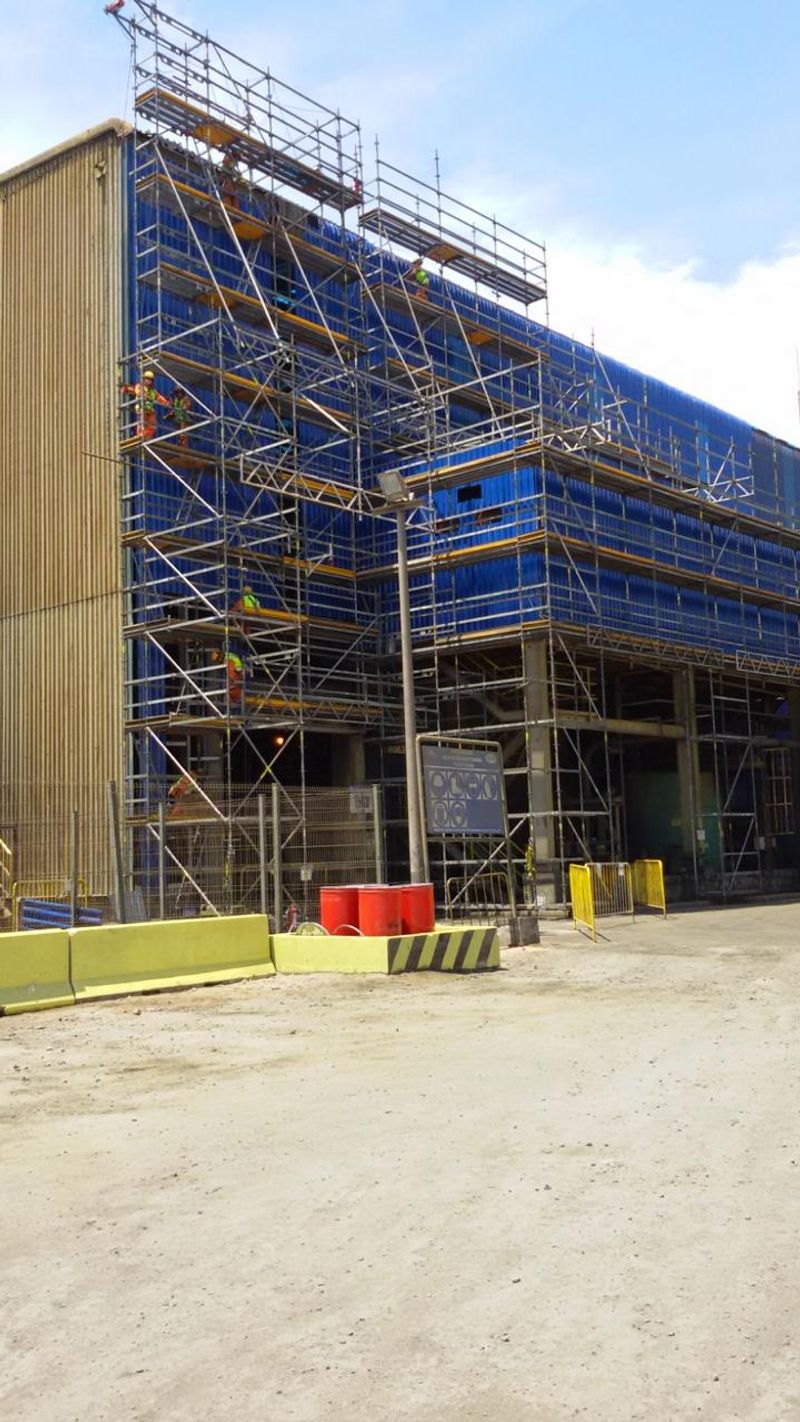 Andamiaje modular cubriendo por completo una estructura industrial de varios niveles