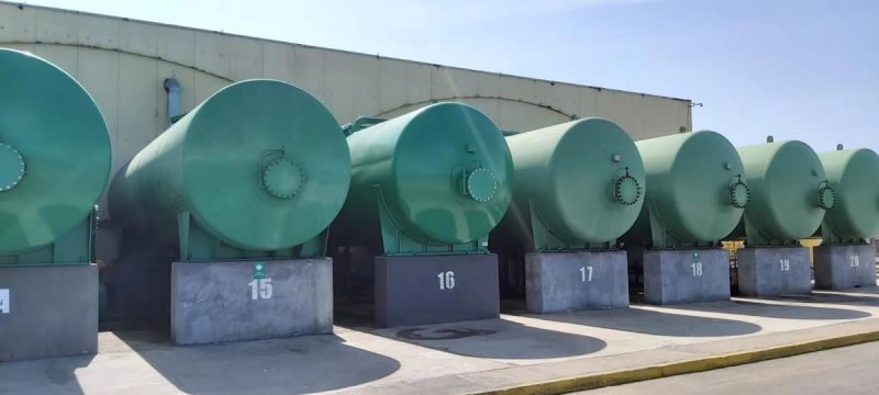 Fila de estanques industriales numerados en faena de mantención de planta de filtrado