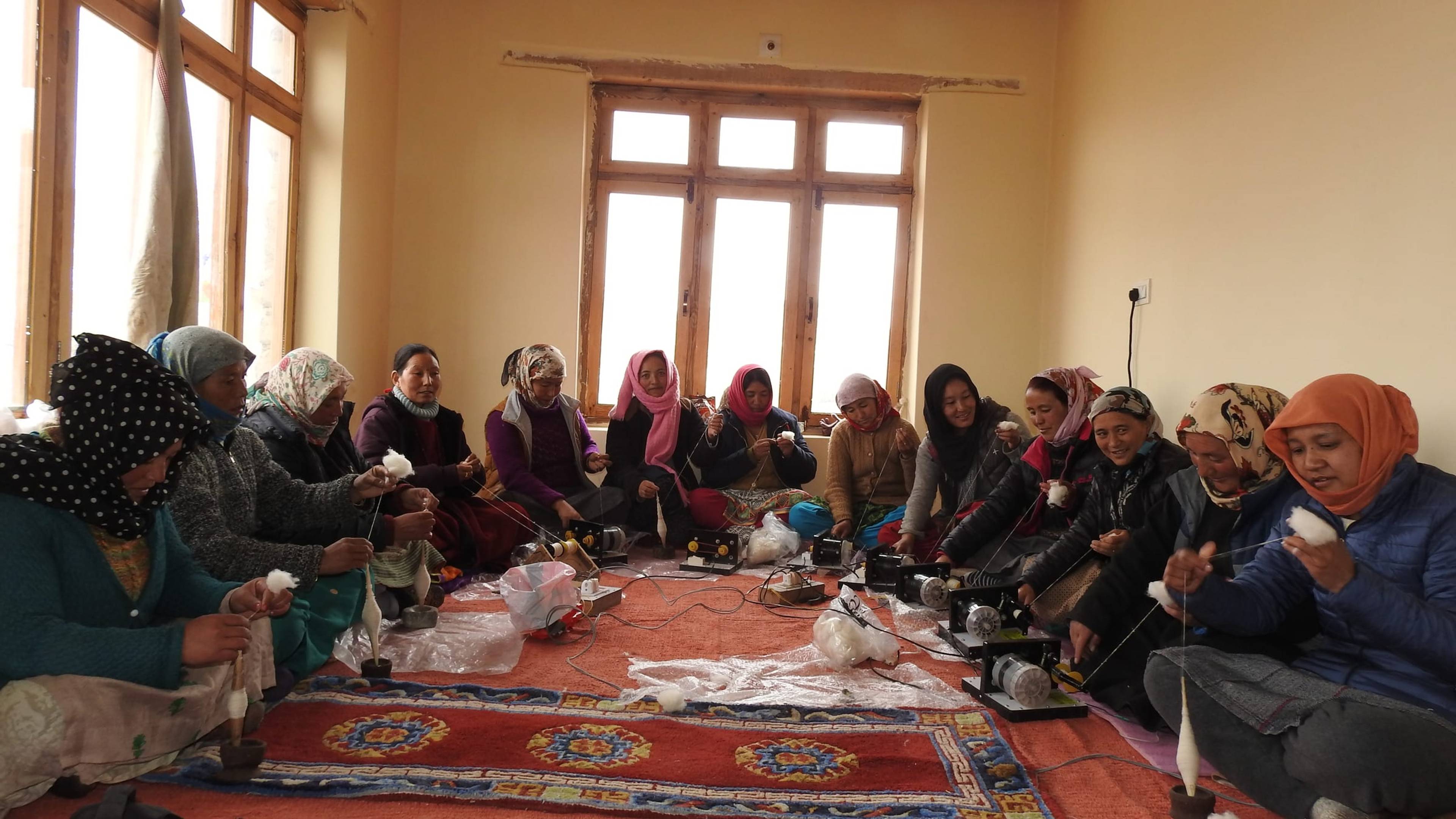 Women in Likir village take part in a wool spinning training, using both traditional drop spindles and motorized spinning devices.