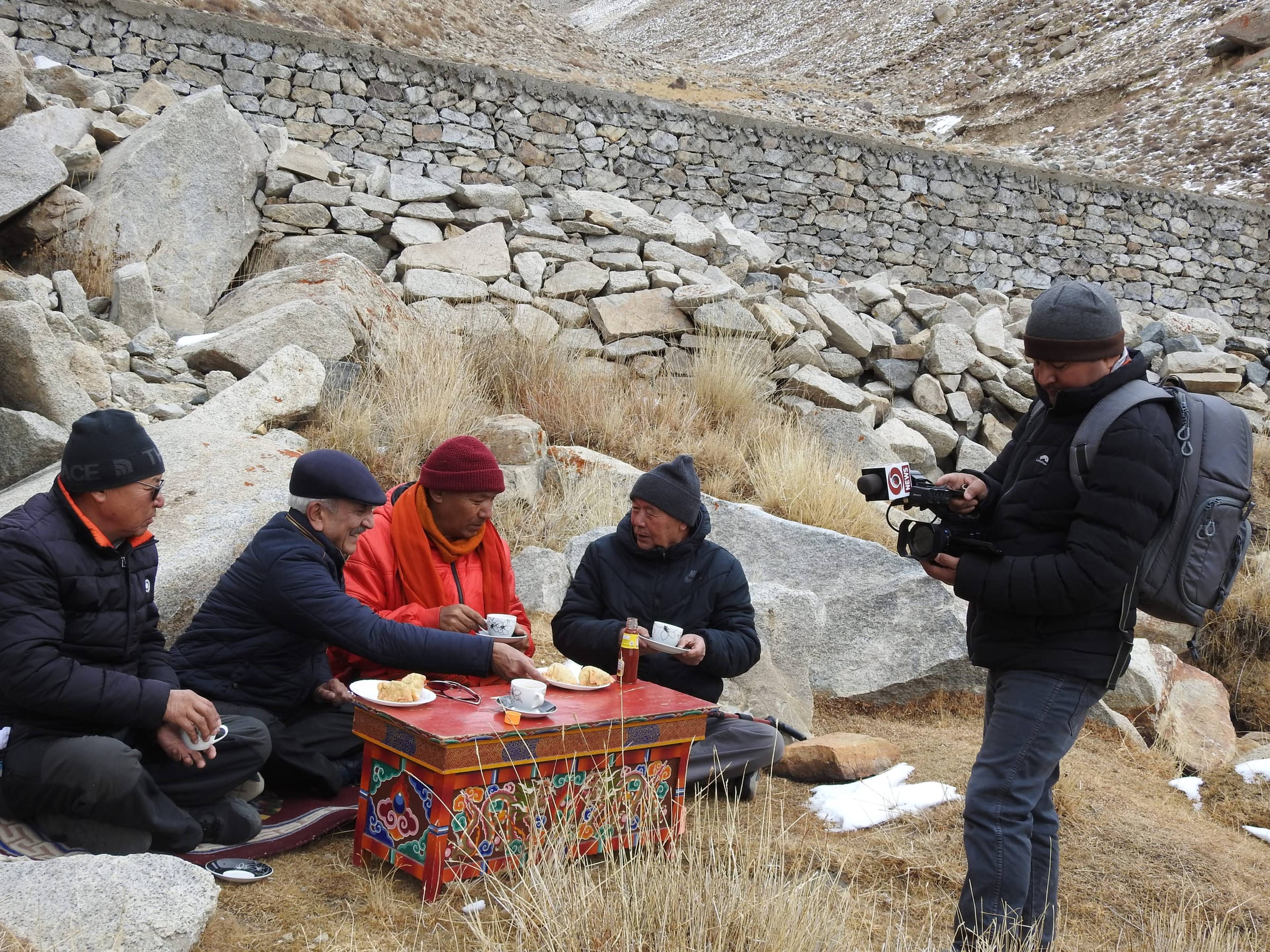 A local news channel covers a community meetup near an artificial glacier site in Gangles, near Khardung La.
