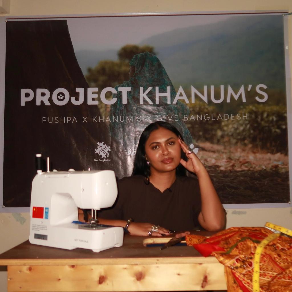Rokeya Khanum, founder of Khanum's sat behind a table with a sewing machine.