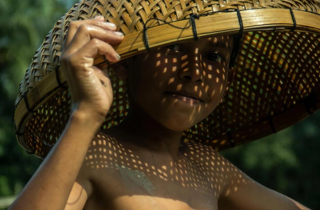 child with bamboo on his head