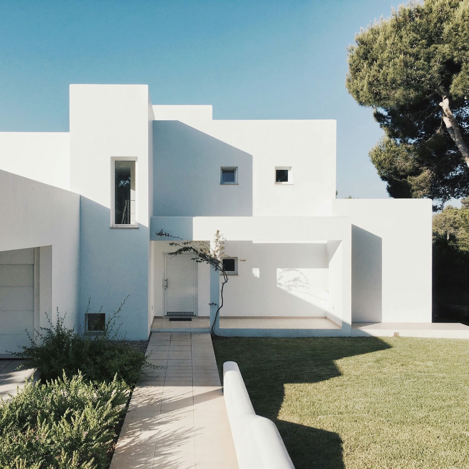 White stucco modern house among pines