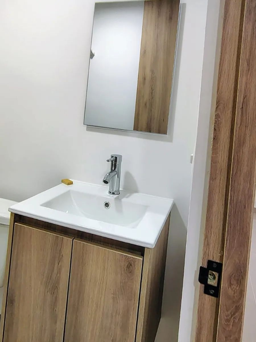 Mueble de lavamanos: Mueble flotante de dos puertas con espejo en la misma veta de madera.