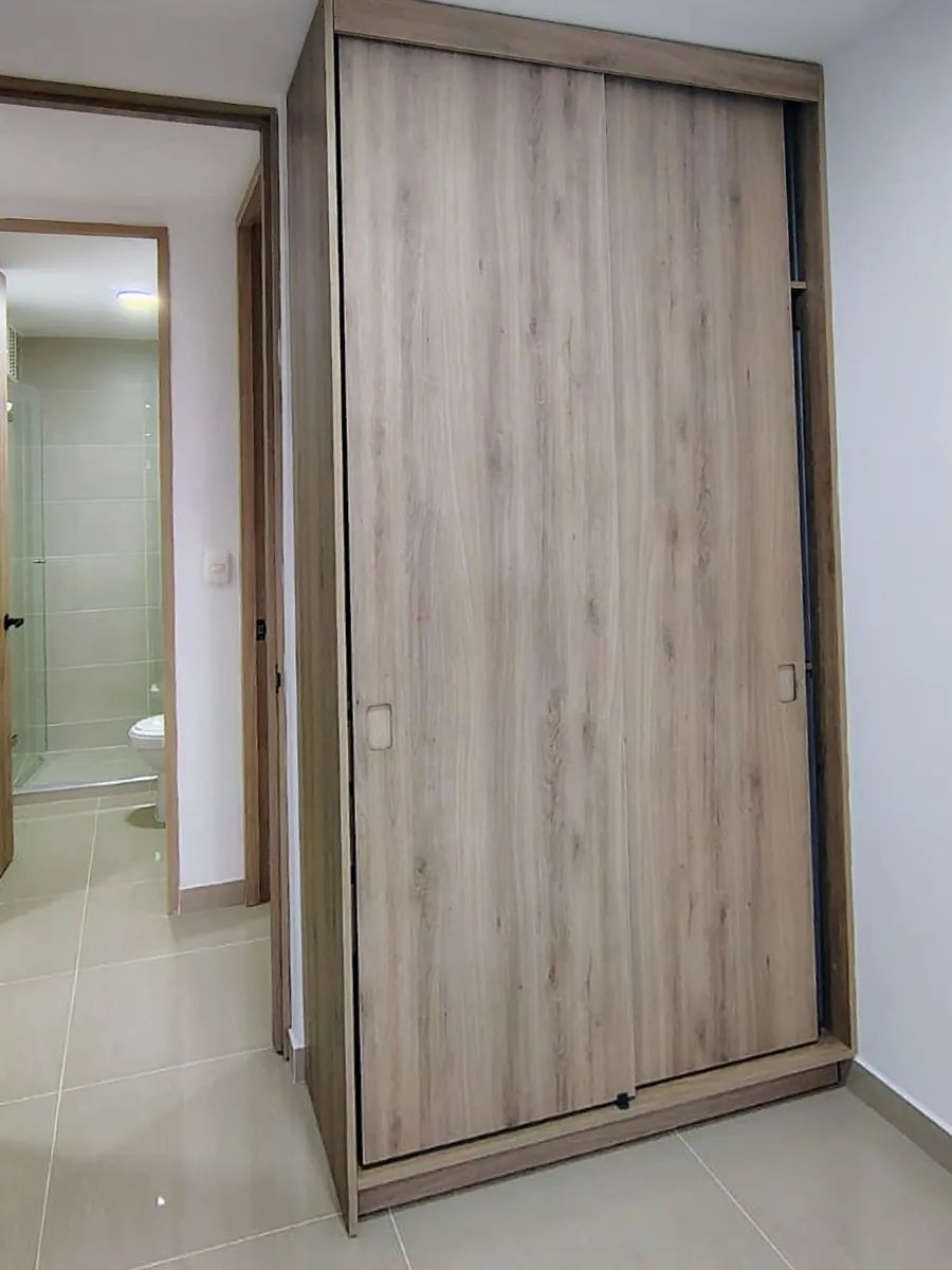 Closet corredizo: Dos puertas corredizas que no ocupan espacio al abrir, ideal para cuartos pequeños.