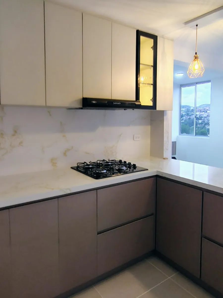 Cocina en L: Muebles bajos en gris topo, altos en blanco y mesón tipo mármol de pared a pared.