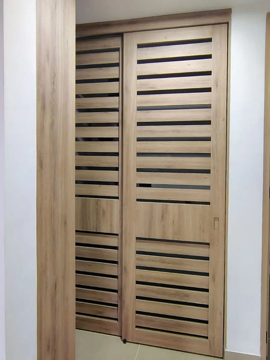 Puertas de área de servicio: Puertas con listones que esconden la zona de ropas y la dejan ventilar.