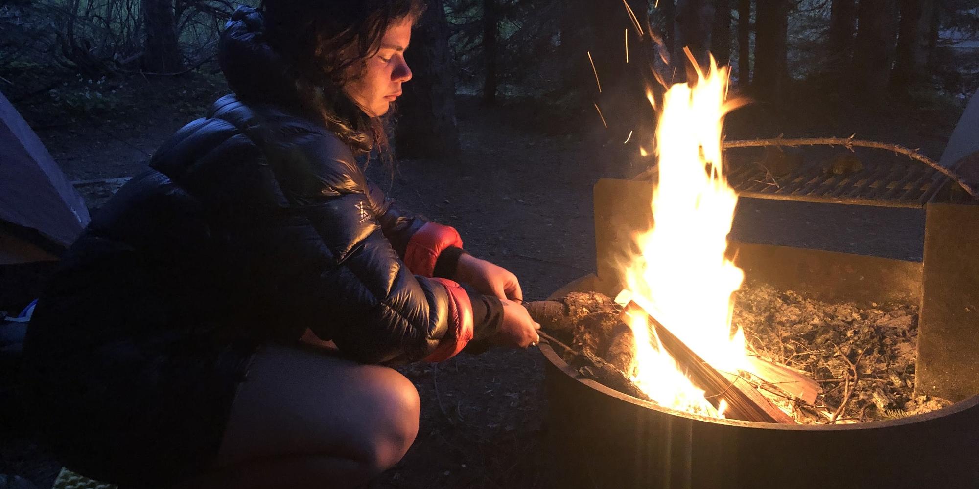 Child sitting by a campfire during Family Adventure camp at Mount St. Helens