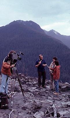 With a backdrop of the blast zone, Mike and Lu Moore give TV interviews in 1981.