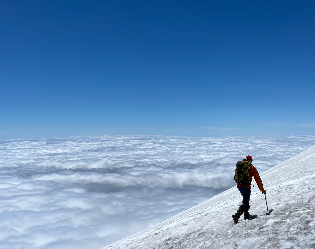 Hiker on Mount St. Helens walking above the clouds