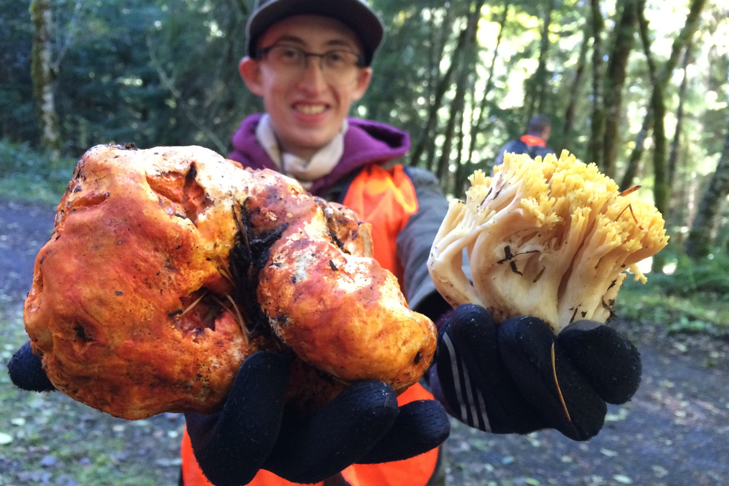 Happy forager holding giant mushrooms