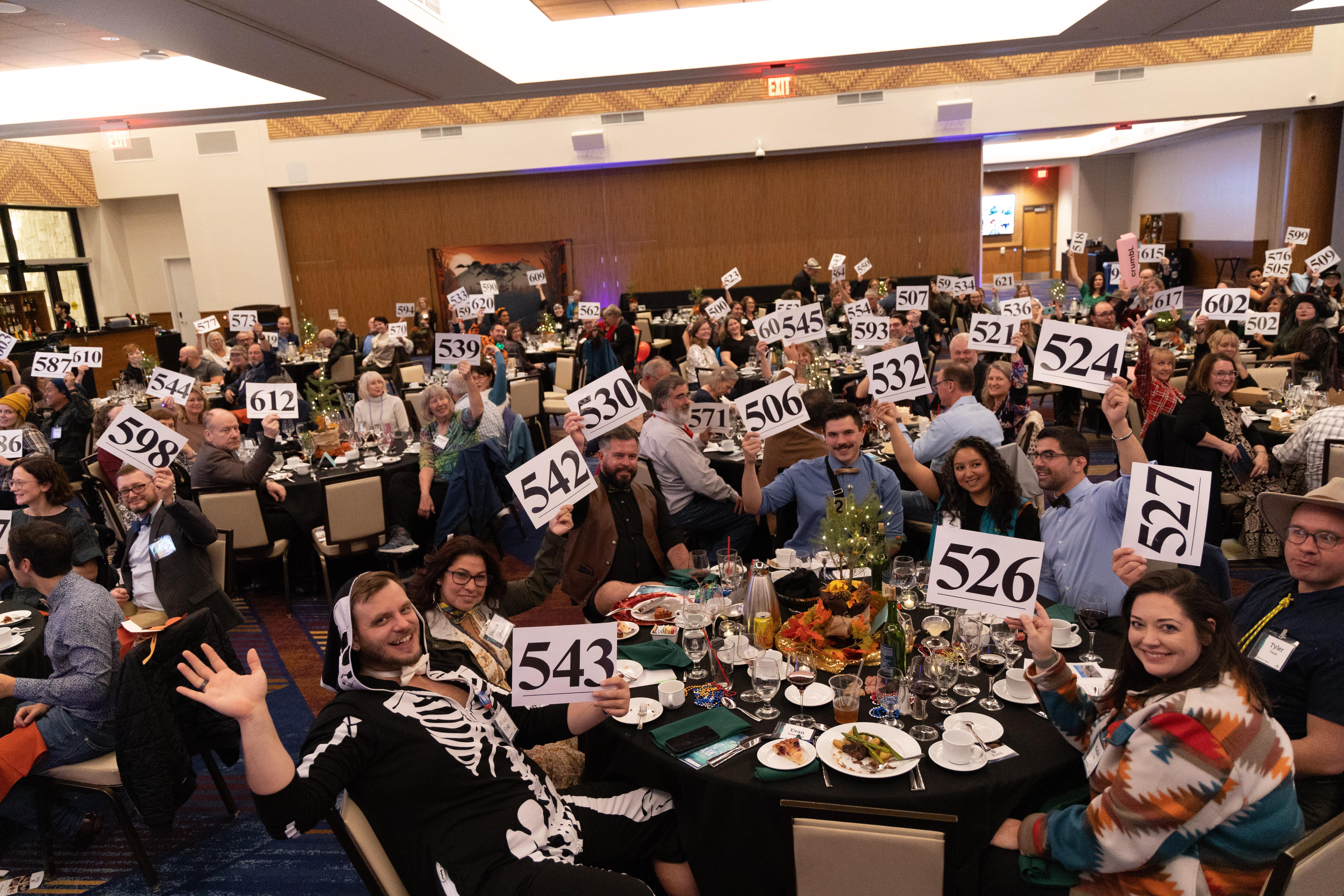 Happy supporters raising their paddles to support MSHI!