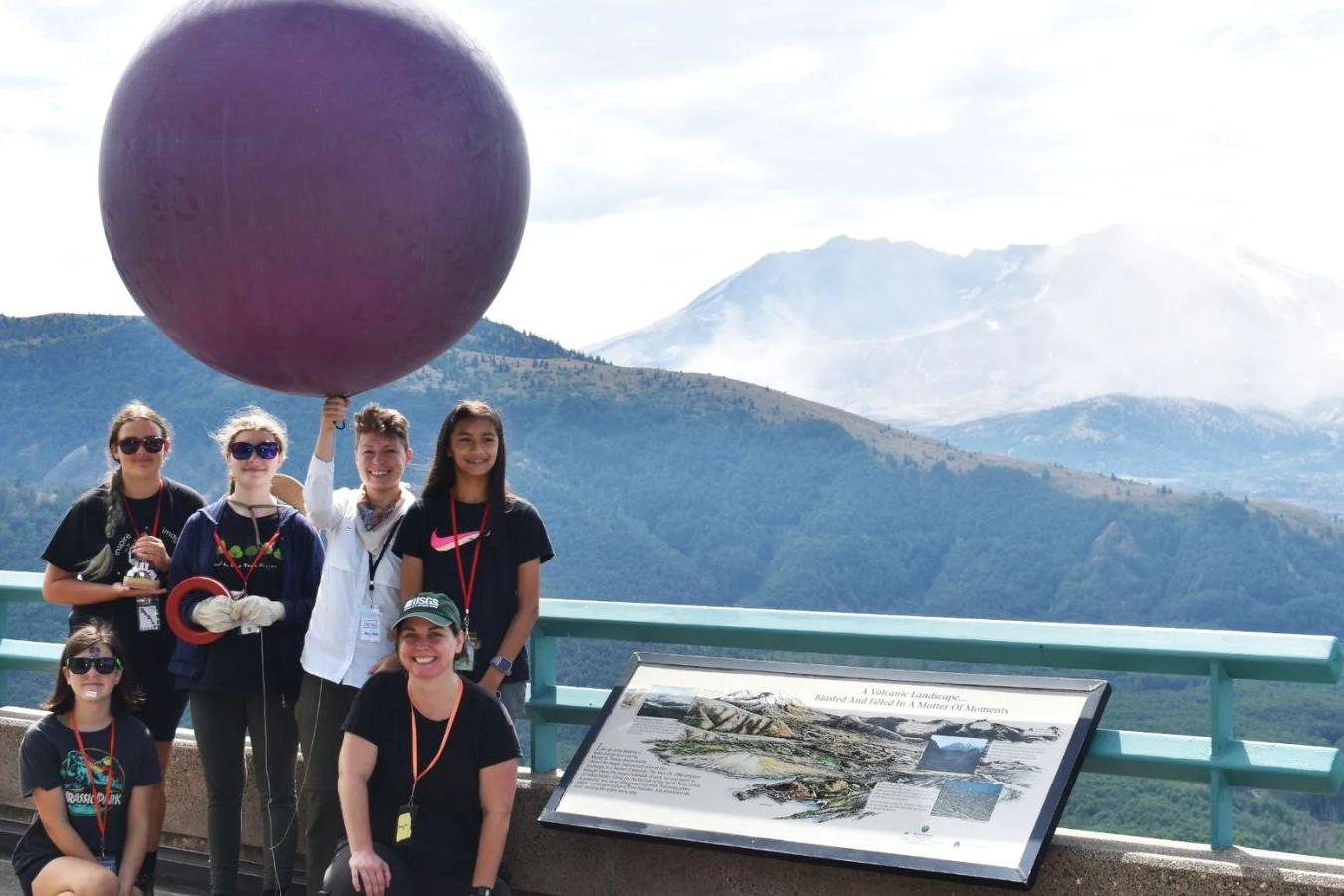 GeoGirls with a large balloon in front of Mount St. Helens