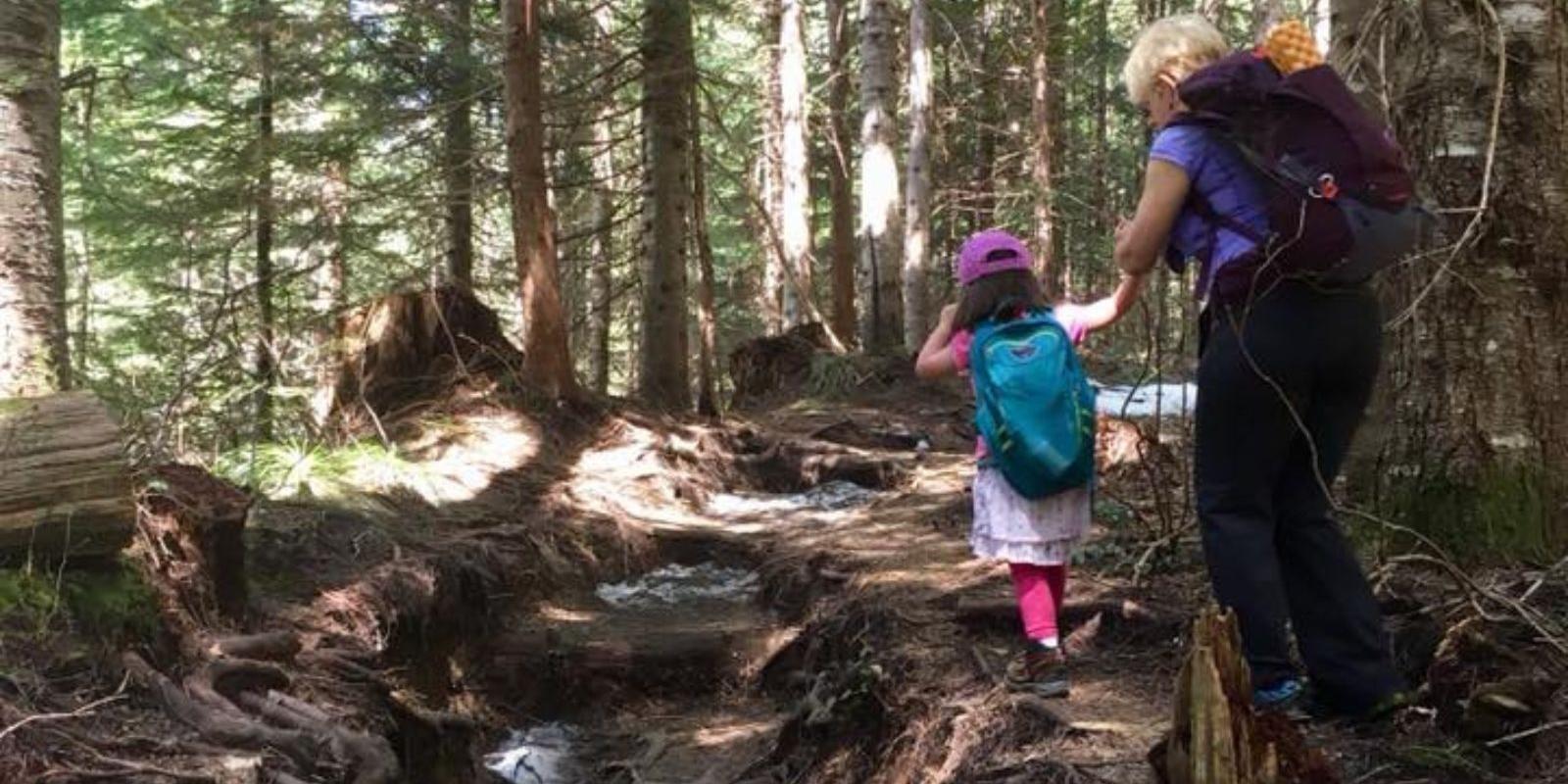 A woman and a child walk through the forest