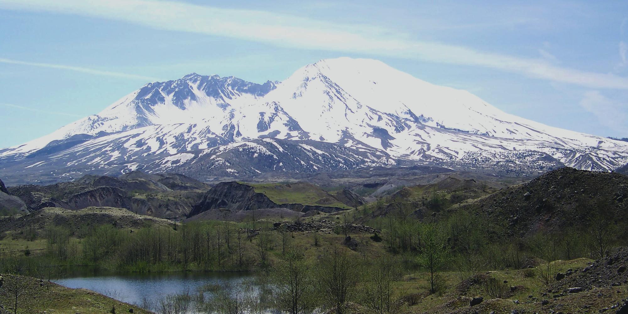 Mount St. Helens in early spring with a dusting of ssnow and hummocks in the foreground