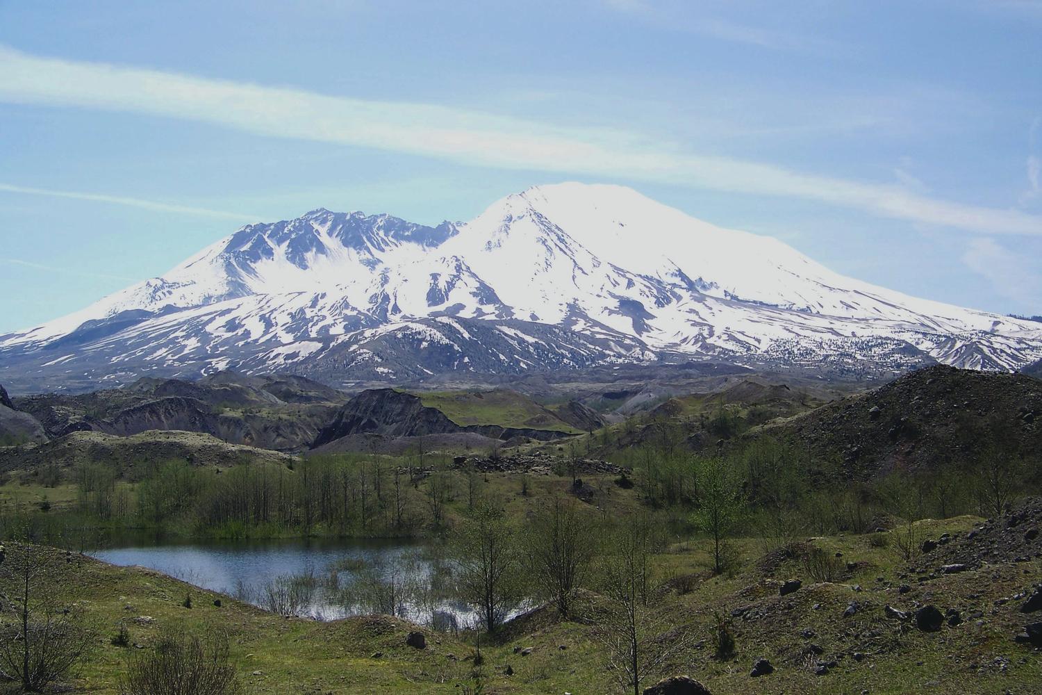 Mount St. Helens in early spring with a dusting of ssnow and hummocks in the foreground