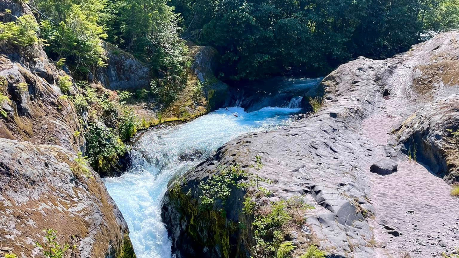 A waterfall flows through a rock canyon