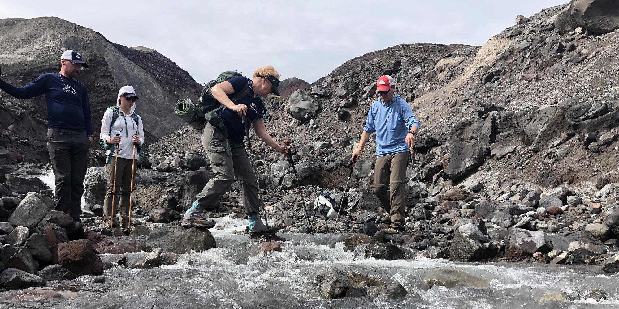 Person crossing Loowit Creek inside the crater of Mount St. Helens