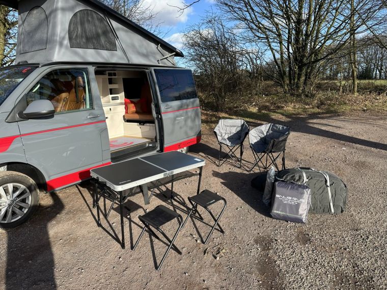 Fenyx parked up with the camping table, chairs and awning bag set out beside it
