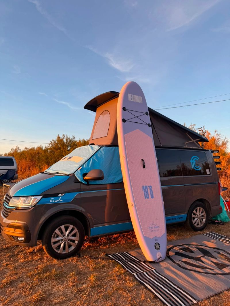 Enola parked up at the campsite with paddleboard by the side at sus set.