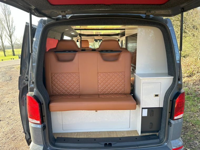 The tan leather rock and roll bench seat in Fenyx, seen through the open tailgate
