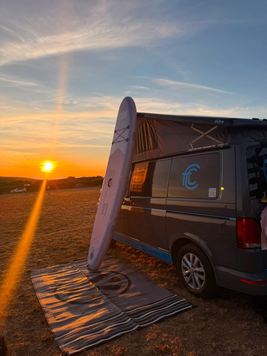 Enola parked up, paddle board next to it overlooking sun set