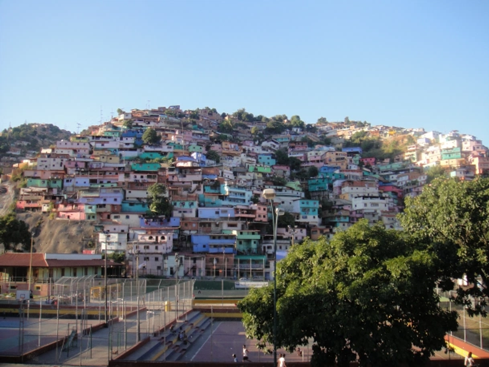 Residential hillside neighborhood with community football courts below, illustrating the environments where many world-class footballers begin playing and developing naturally.