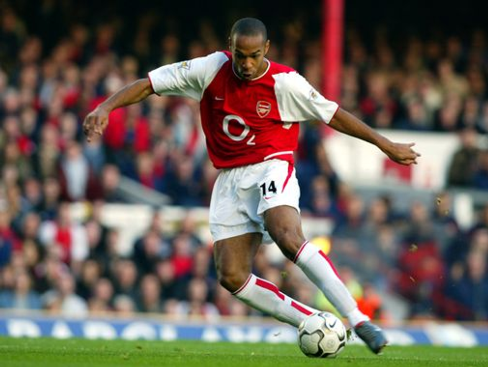 Thierry Henry controlling the ball during a Premier League match, illustrating the fluid movement and athletic characteristics associated with world-class footballers.