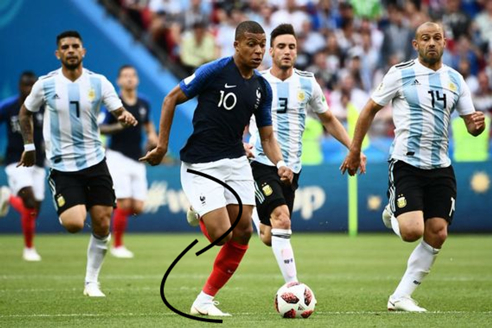 Professional footballer Kylian Mbappé accelerates with a powerful stride during a match, highlighting coordinated lower-body mechanics and efficient force transfer used by elite athletes.
