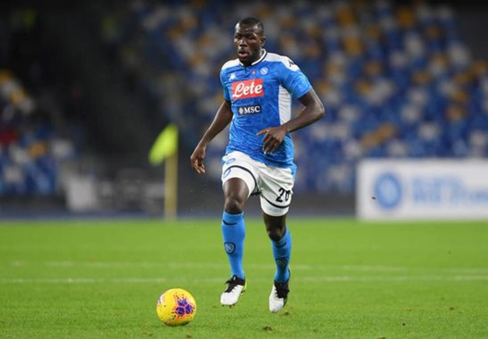 Kalidou Koulibaly running with the ball during a Napoli match, demonstrating athletic movement and control in open play.