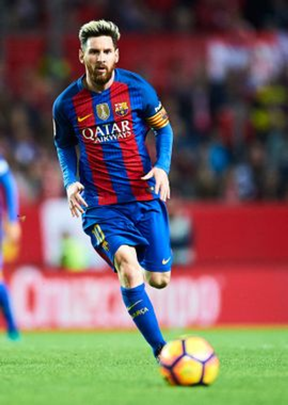 Lionel Messi dribbling with the ball during a match, representing the natural movement, foot function, and athletic qualities of world-class footballers discussed in this article.