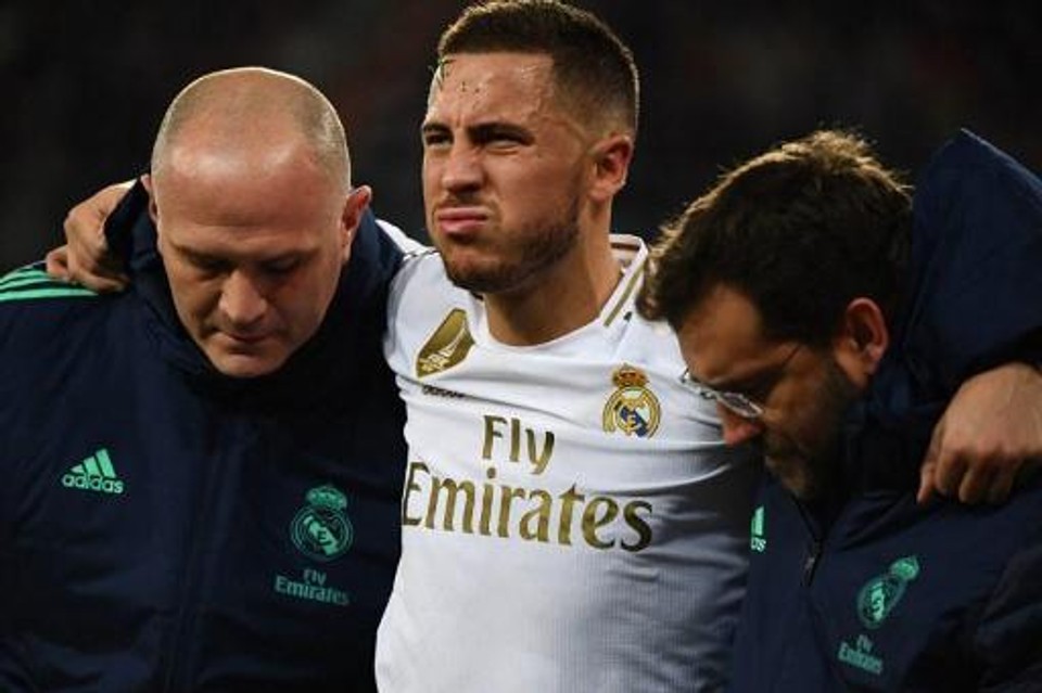 Professional footballer Eden Hazard is helped off the pitch by medical staff after sustaining an injury during a match, illustrating how even world-class players can have their careers disrupted by injury.