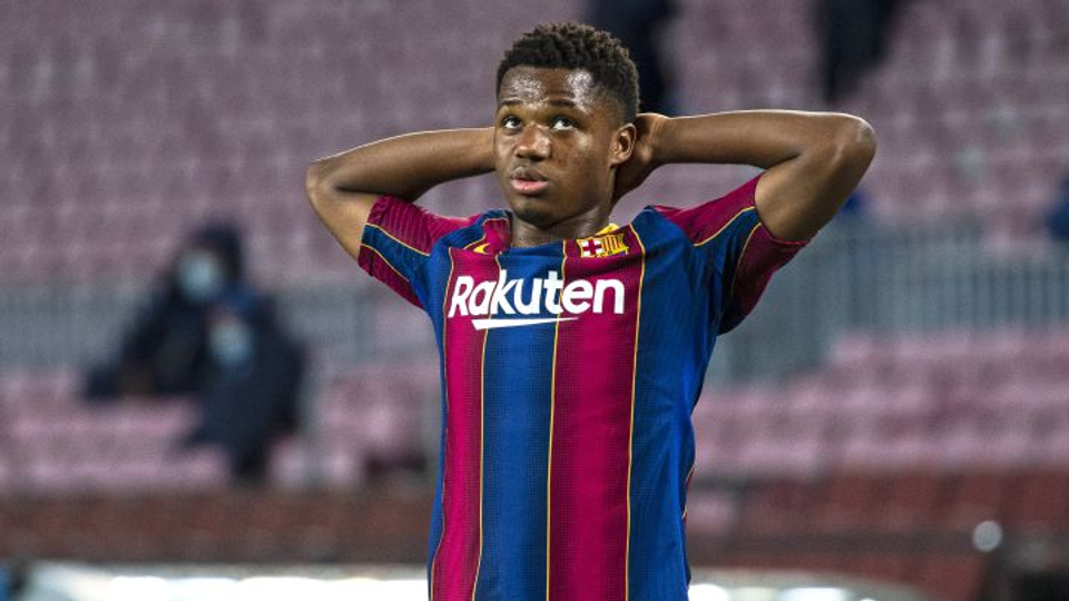 Professional footballer Ansu Fati stands on the pitch with his hands behind his head during a match, representing the frustration and uncertainty that injuries can bring to even the brightest young talents.