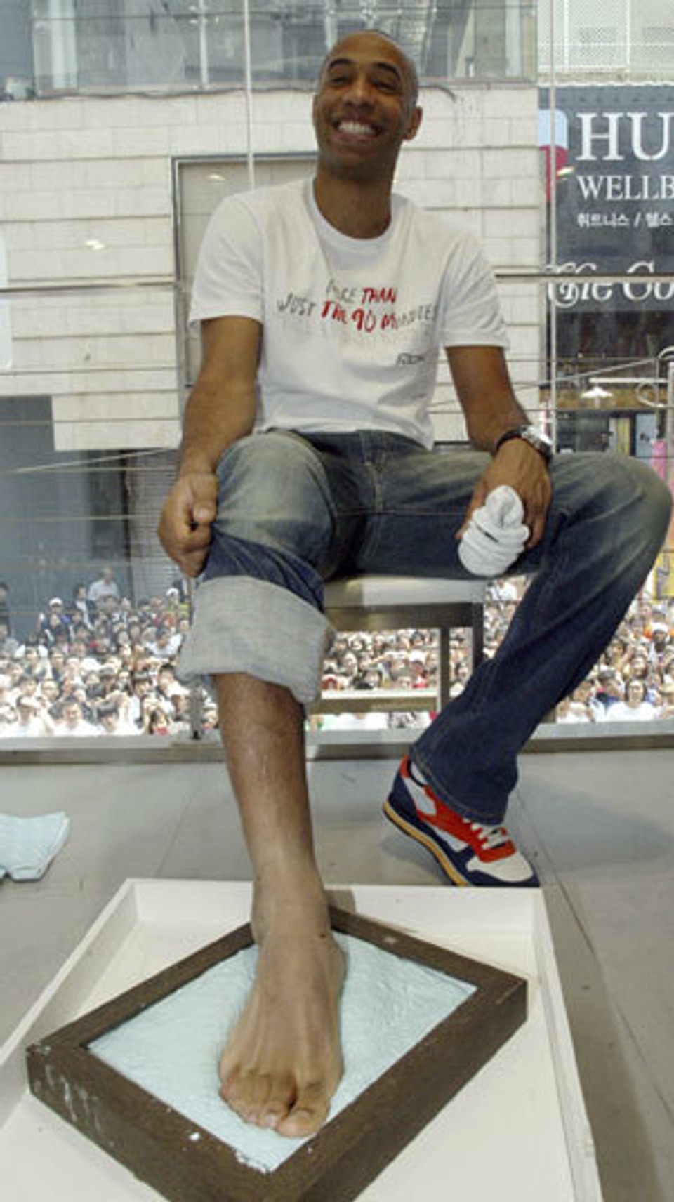 Thierry Henry displaying the footprint of his bare foot, illustrating the distinctive foot structure and characteristics associated with world-class footballers.