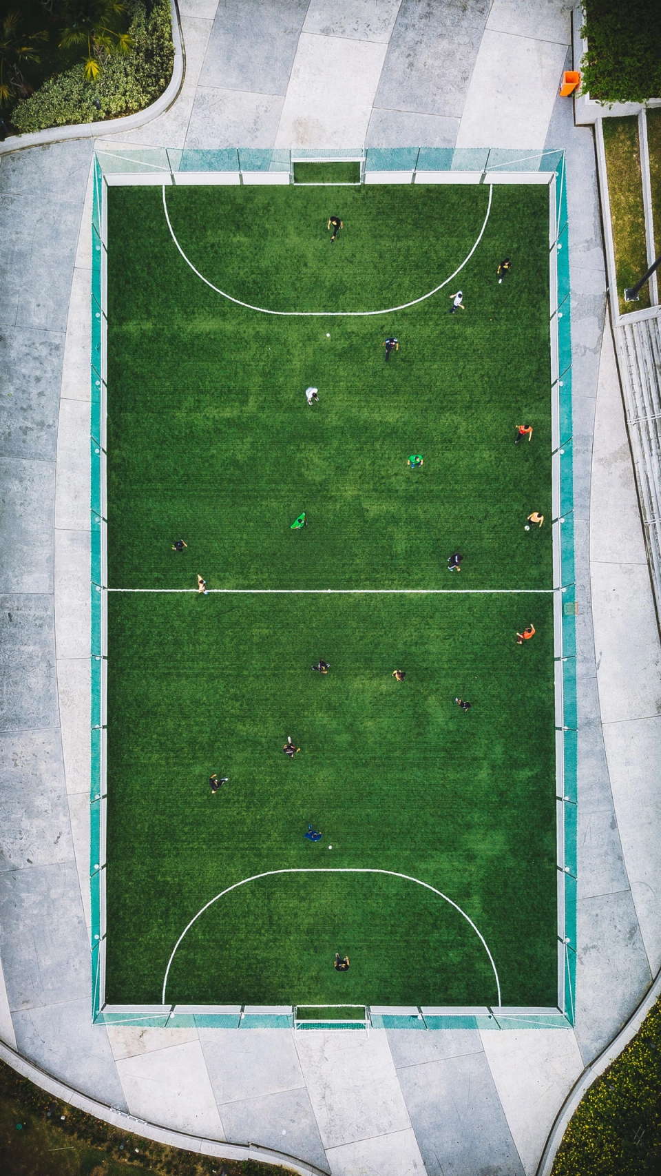 Aerial view of a small-sided football pitch with players spread across the field, illustrating the dynamic movement and spatial complexity of the game.